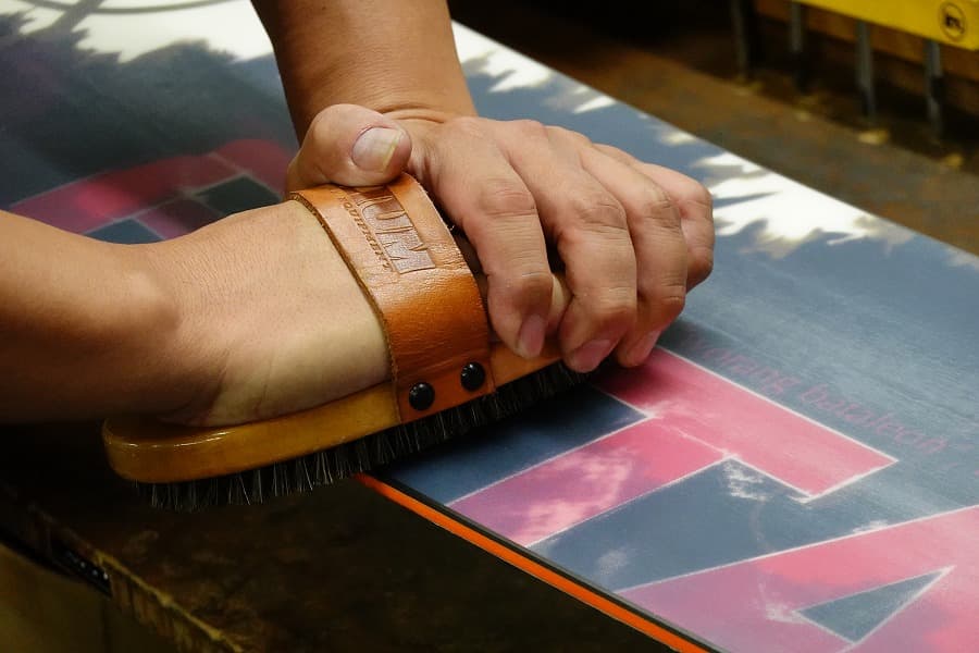 ボードにブラシをかける坂本壮氏（アップ）